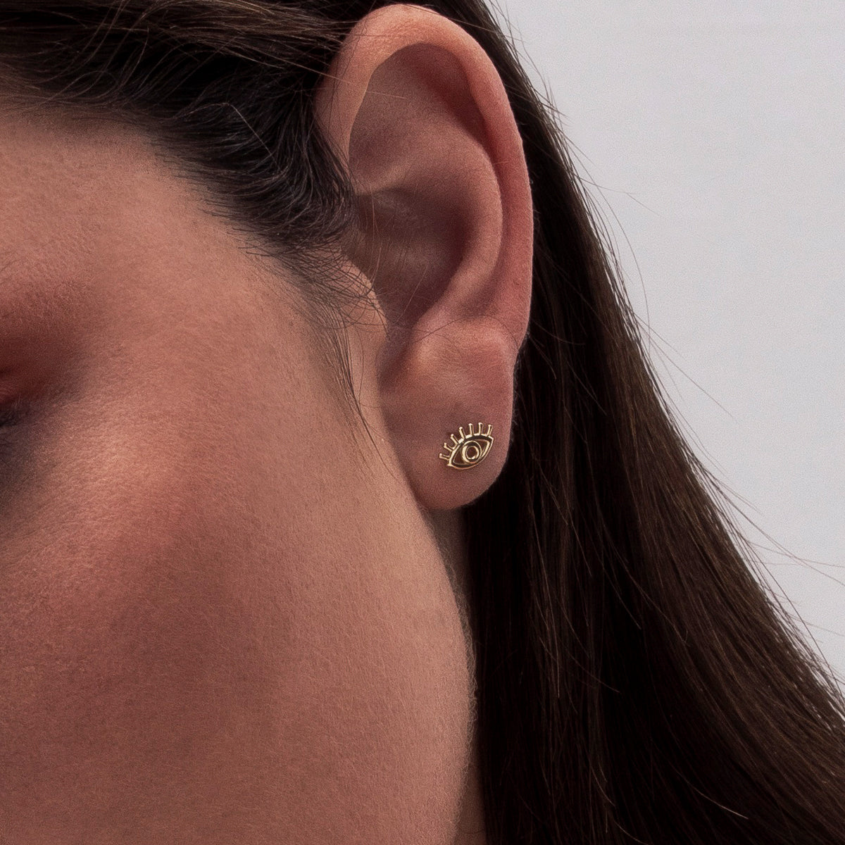 Stud earrings with a small gold eye design