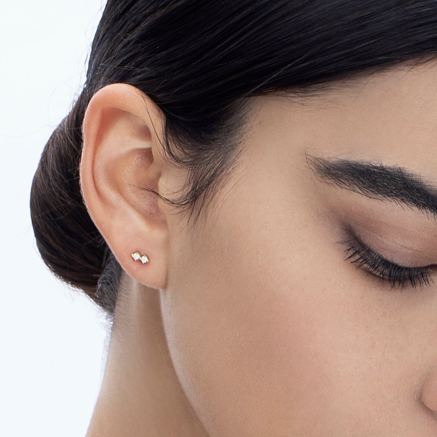 Tight gold earrings studded with two diamonds
