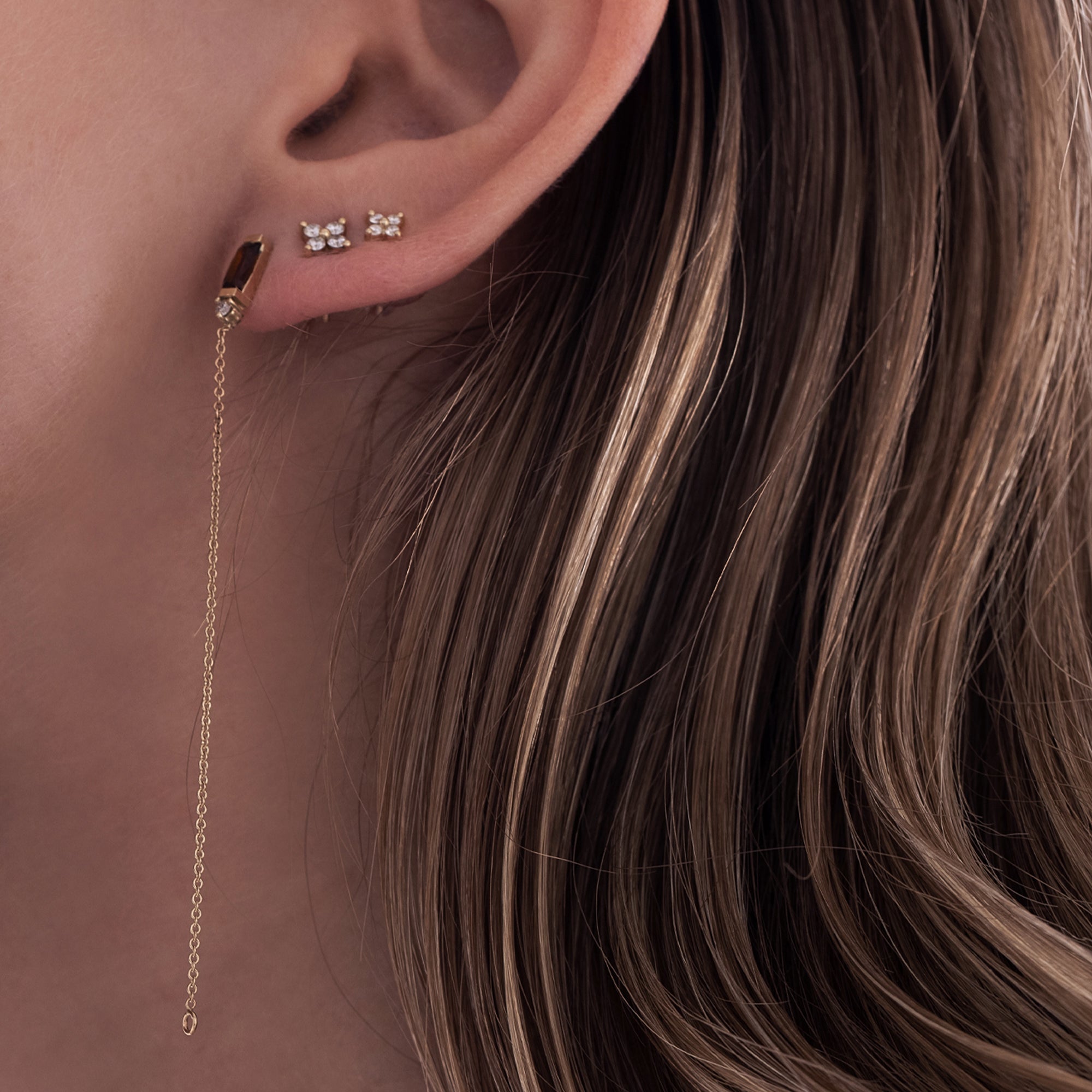 A special gold chain earring studded with gemstone, tourmaline and diamond