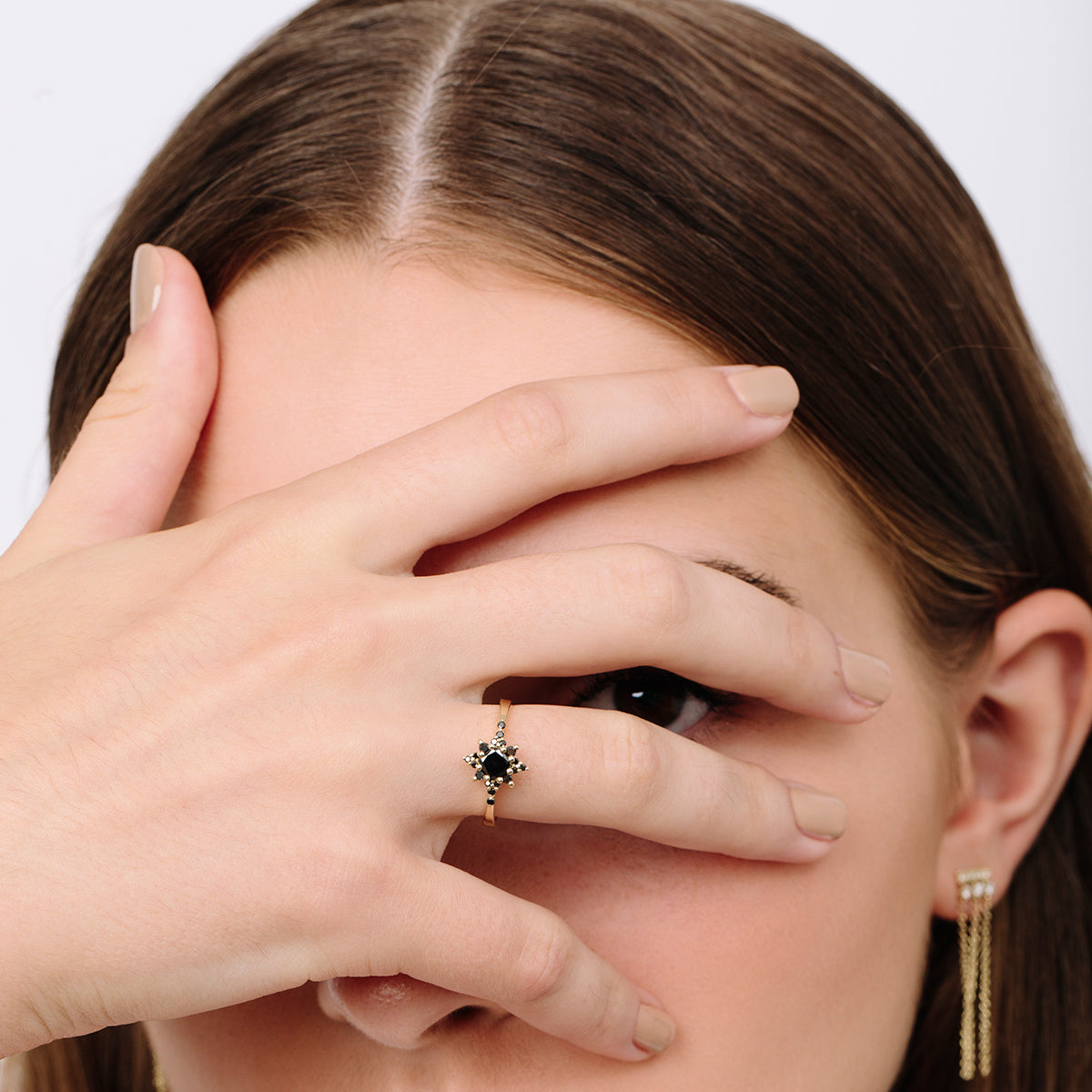 A black diamond star ring, with a central brilliant cut diamond