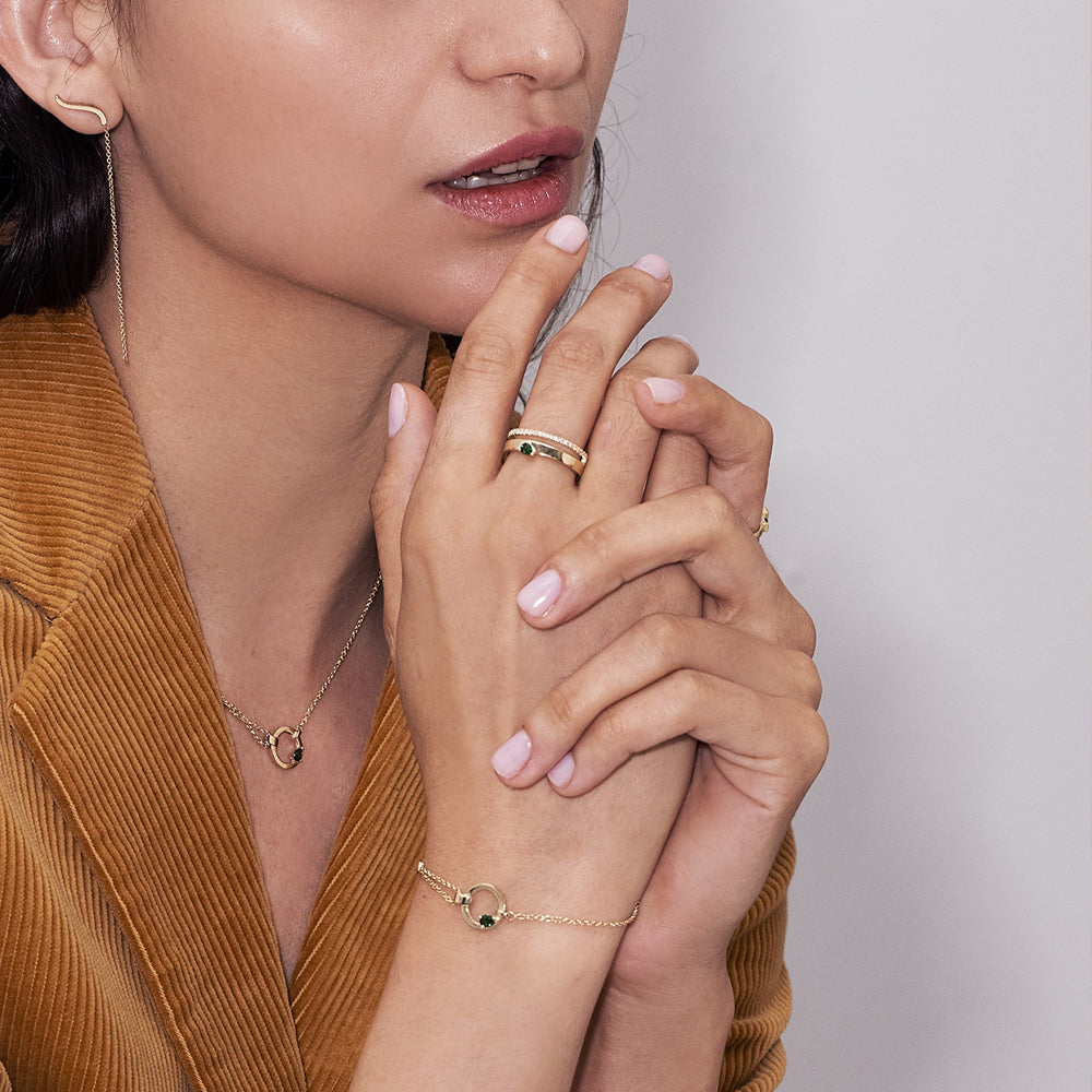 A special asymmetric gold bracelet, in a modern and impressive design. Inlaid green tourmaline and diamond.