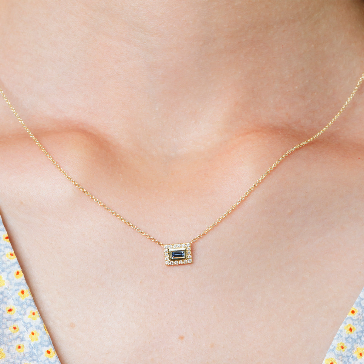 A baguette cut gold chain studded with diamonds and sapphires