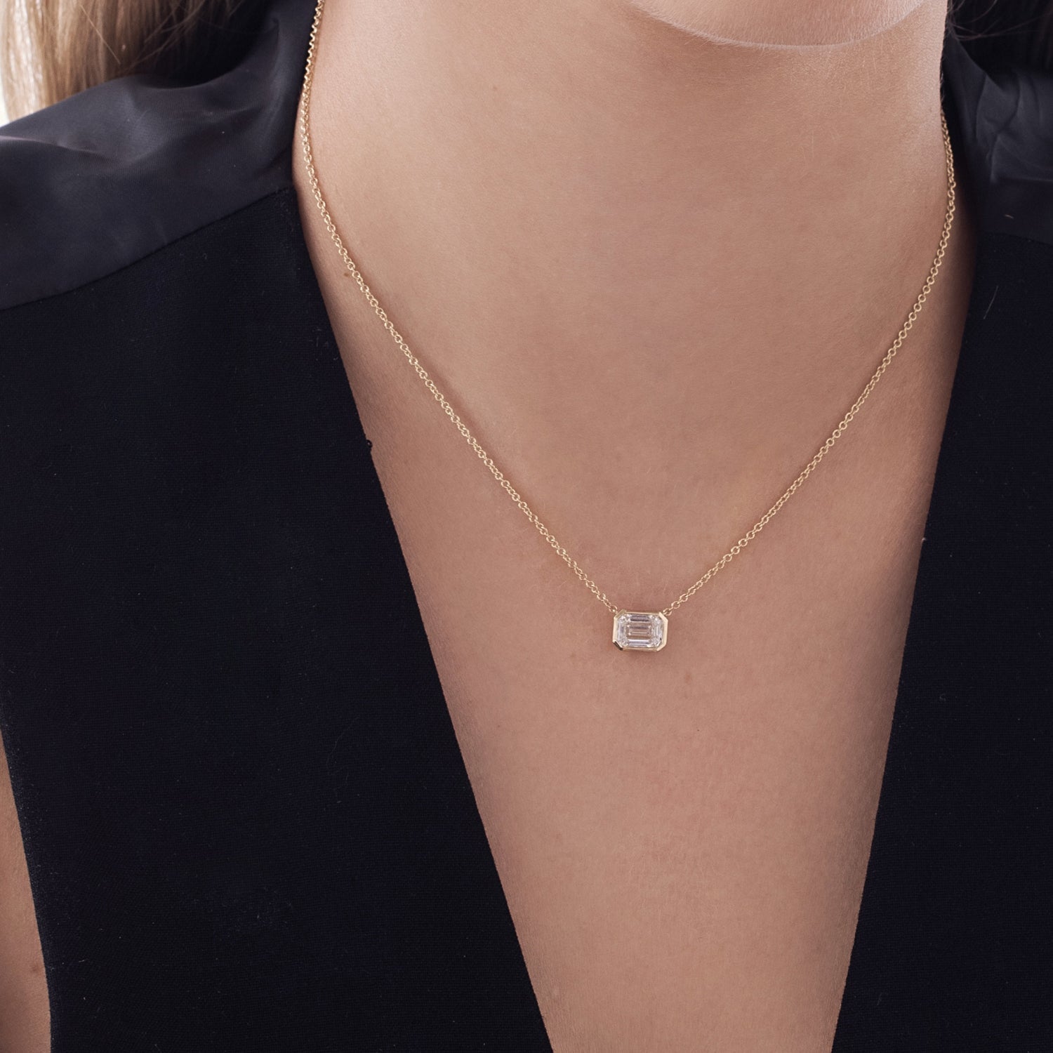 A classic gold necklace set with a 1 carat emerald cut lab diamond