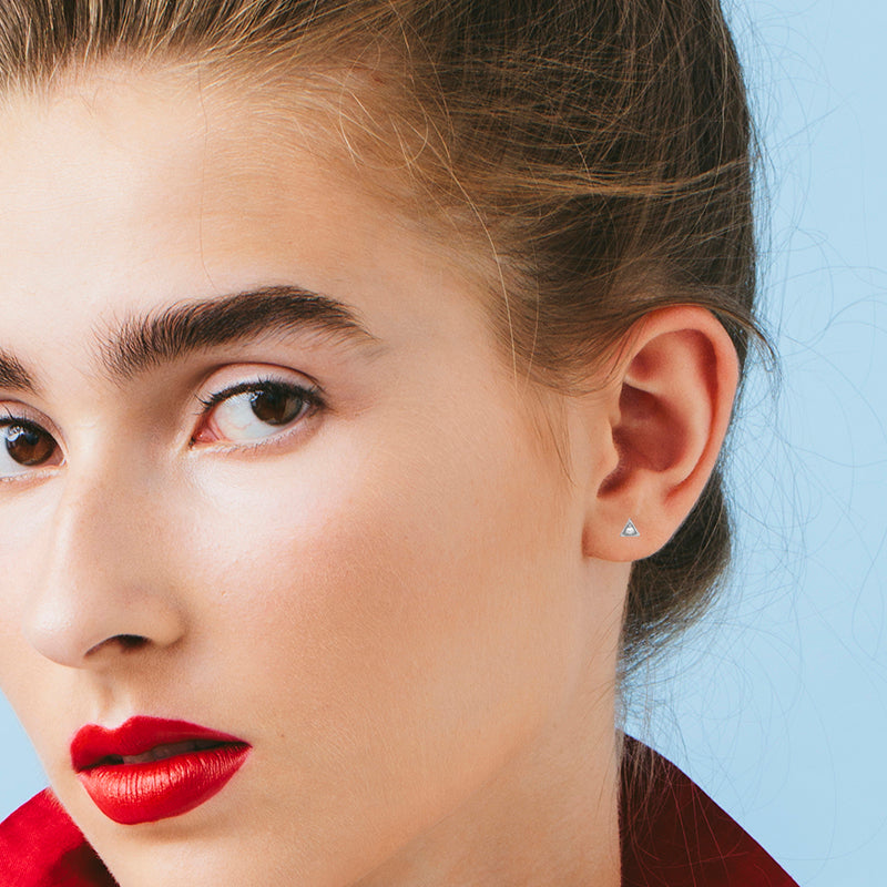 Small attached round diamond earrings in a triangular frame