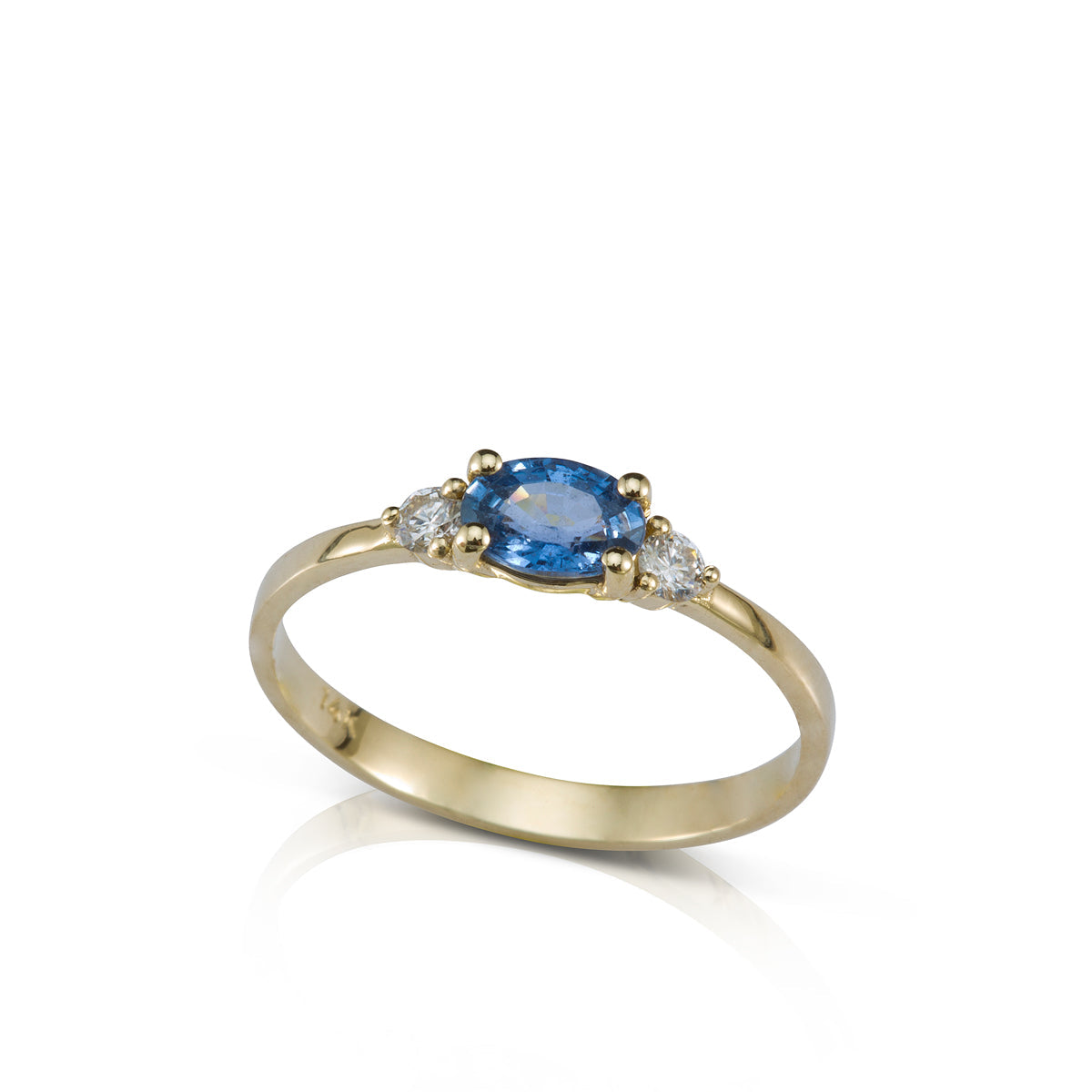 A gold ring set with an oval sapphire and 2 side diamonds