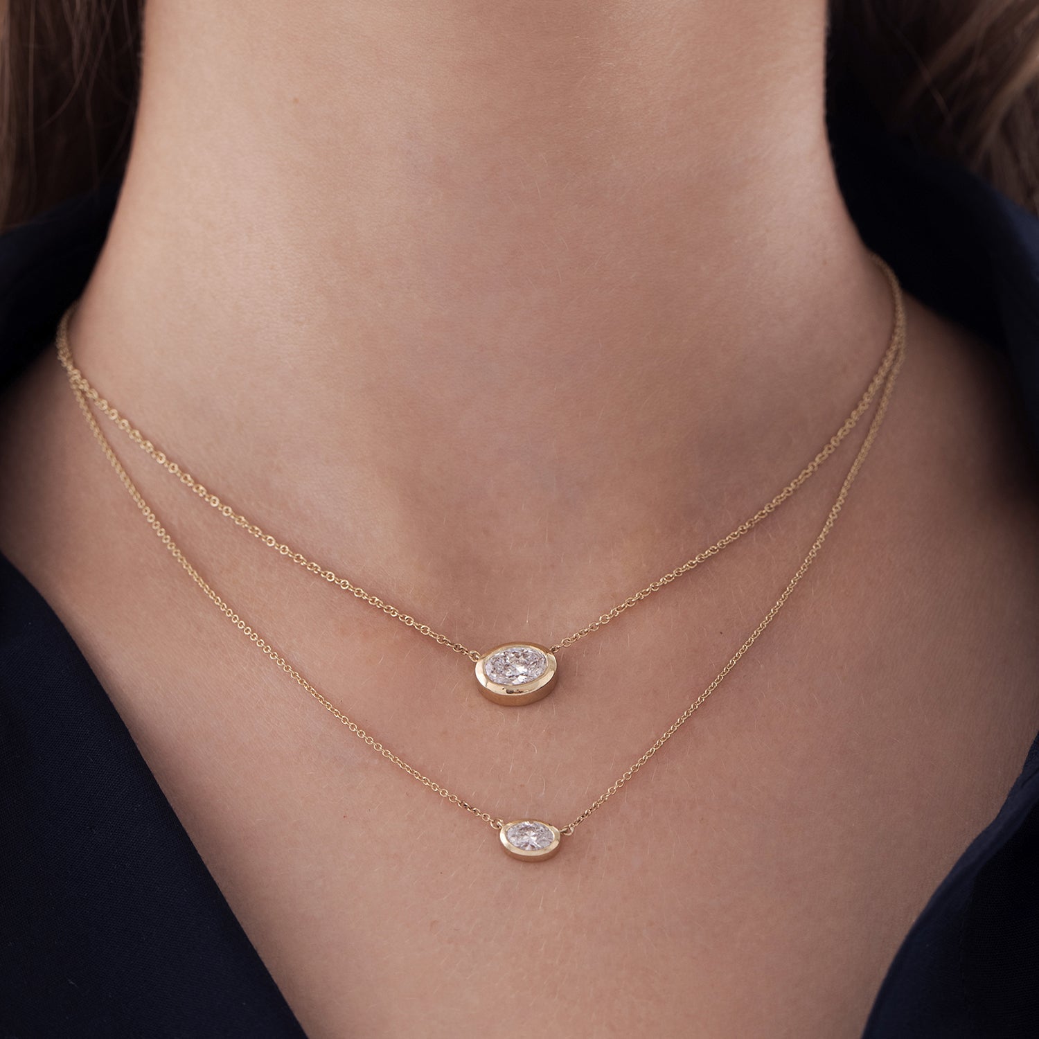 A classic gold necklace set with an oval-cut lab diamond