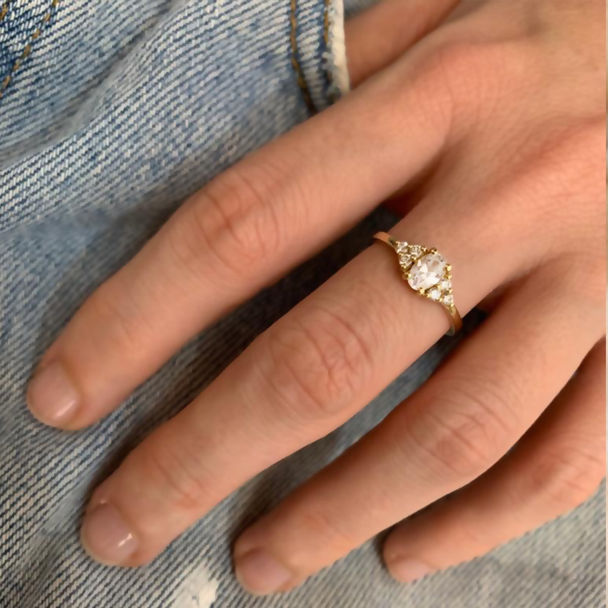 An engagement ring set with a central oval diamond and 6 side diamonds