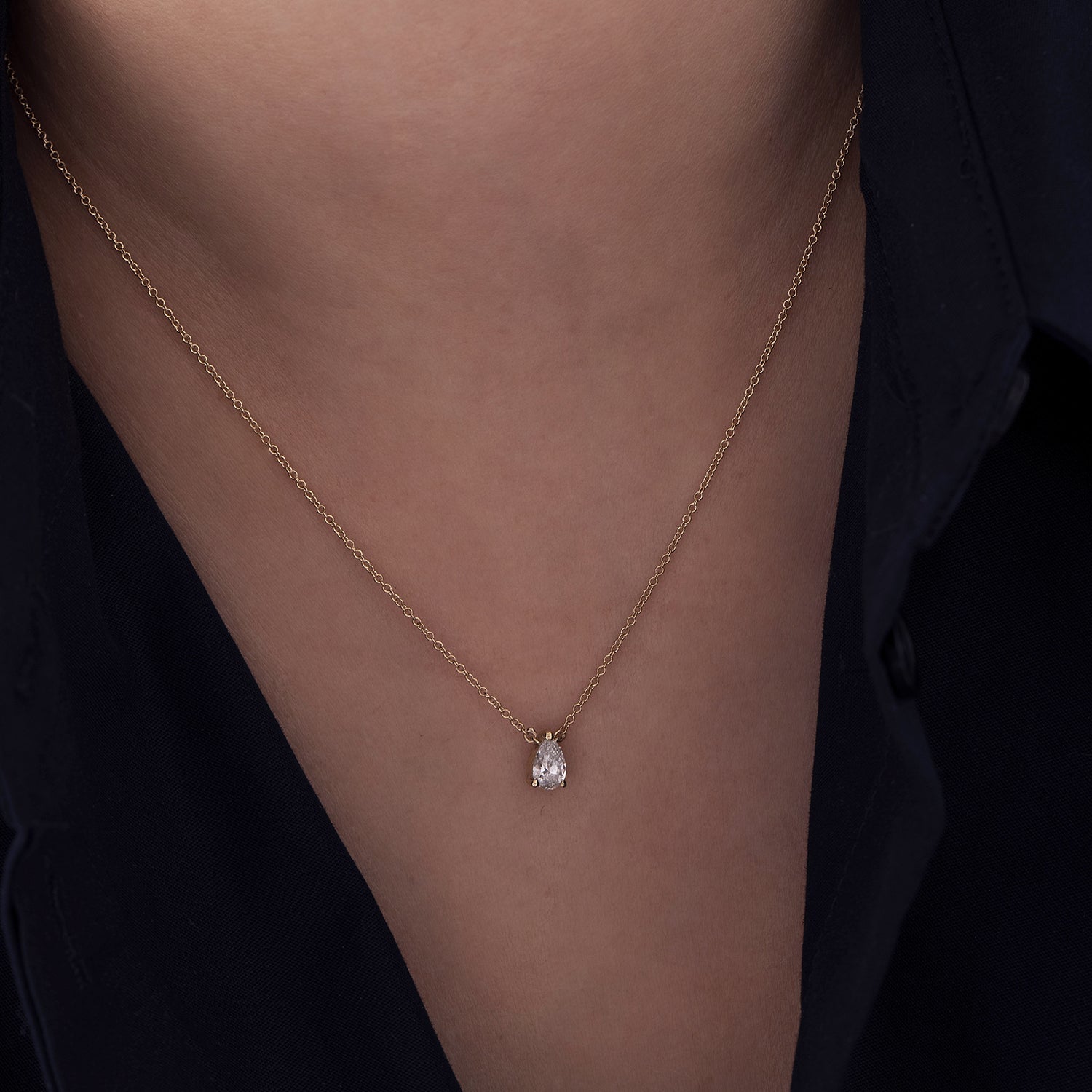 A classic gold chain set with a drop-cut lab diamond
