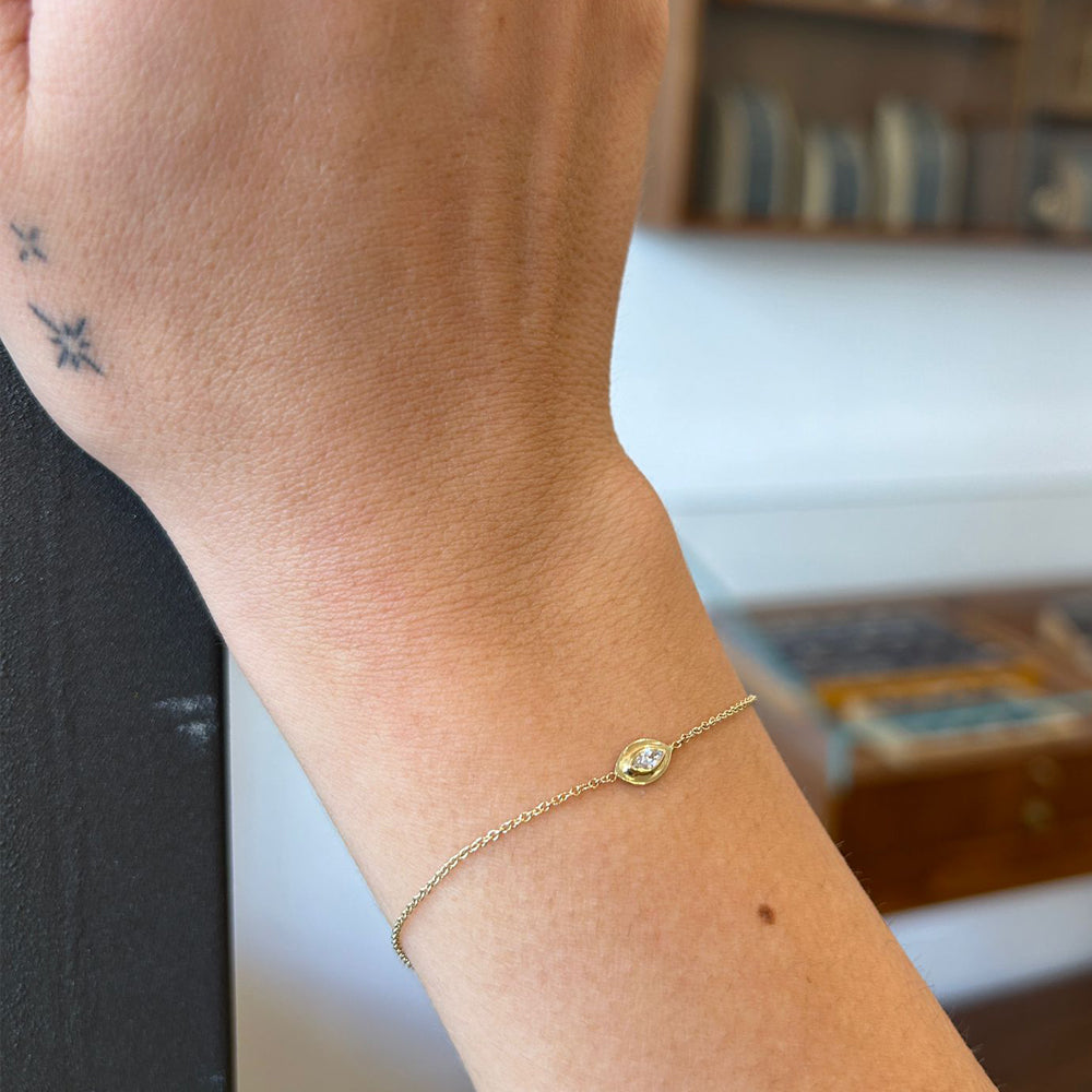 A delicate gold bracelet in the modern Ein Hare style, set with a marquise-cut natural diamond