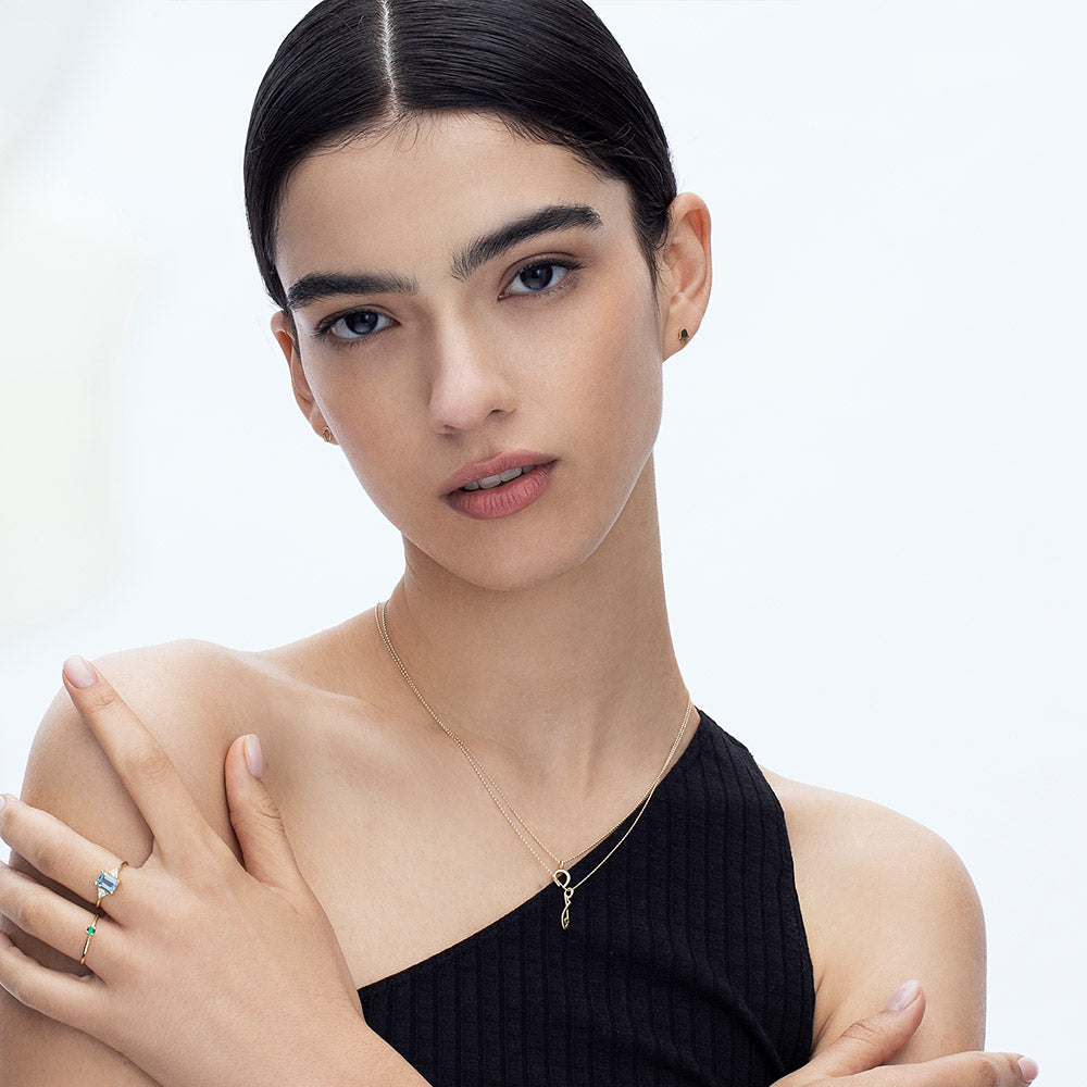 Gold necklace with an emerald-studded fish pendant