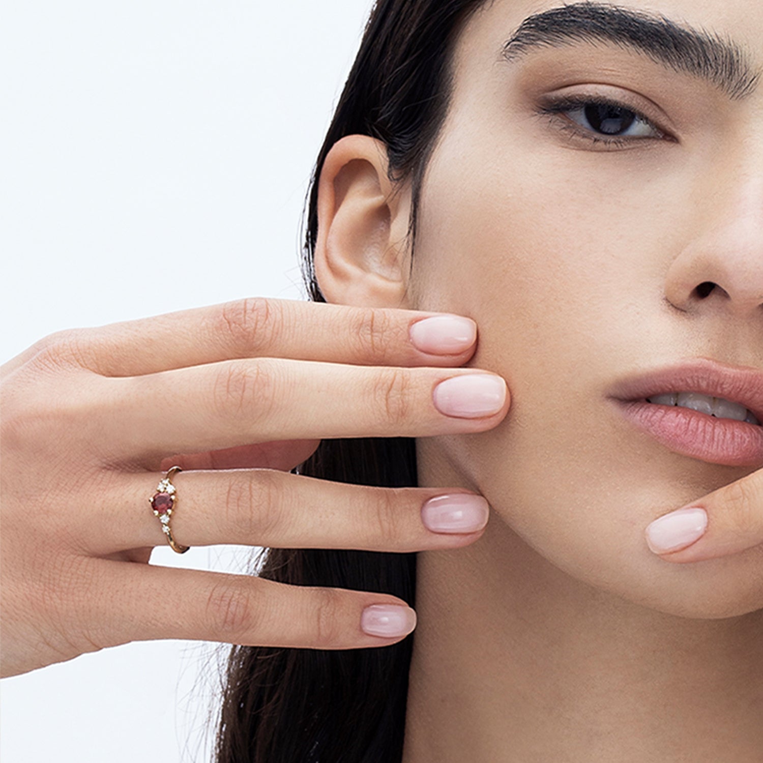 An engagement ring set with rhodolite and small one-centimeter diamonds