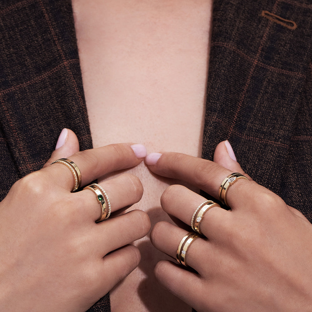 A double gold ring set with a row of diamonds and a smooth wide band