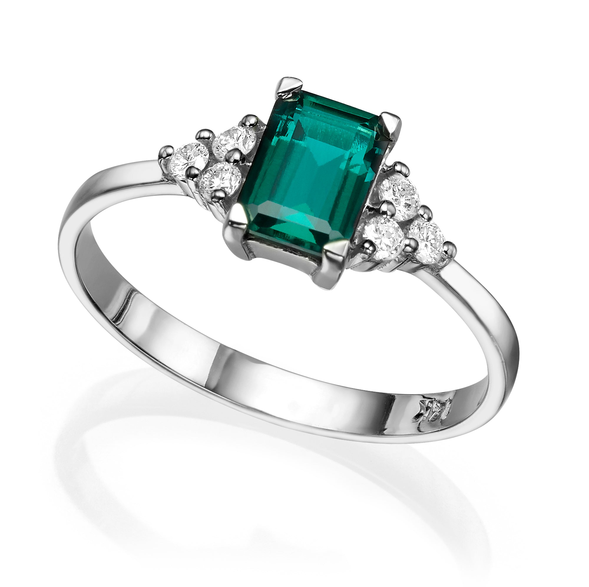 An engagement ring set with a rectangular lab emerald and 6 sided diamonds
