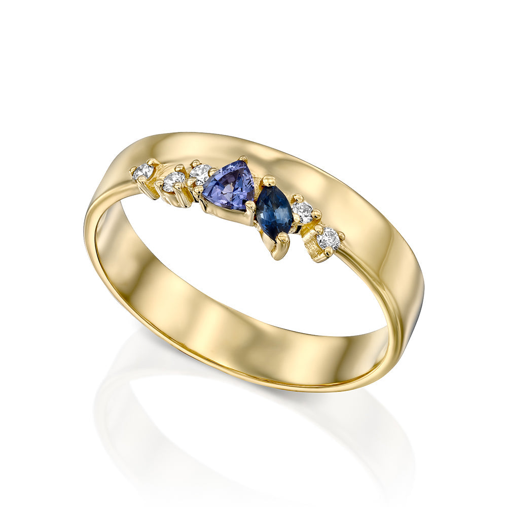 A wide gold ring with a special asymmetric setting of tanzanite, sapphire and diamonds
