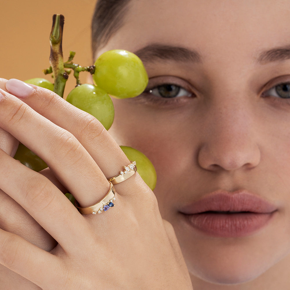 A wide gold ring with a special asymmetric setting of diamonds in a variety of cuts
