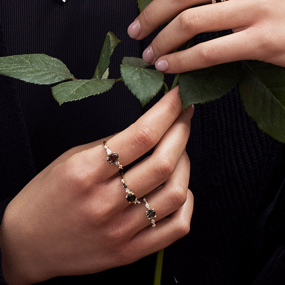 A gold ring set with smoky quartz and drop and round cut diamonds
