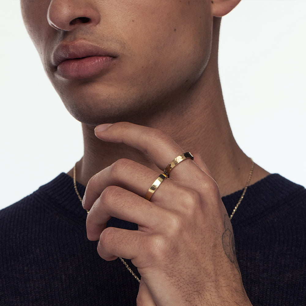 A wedding ring for a man and a woman: a flat gold ring with a fine braided texture, 4 mm wide