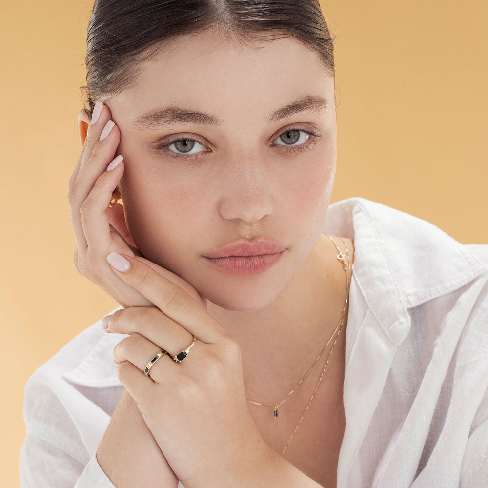 A semi-eternity ring set with baguette-cut black diamonds and princess-cut white diamonds