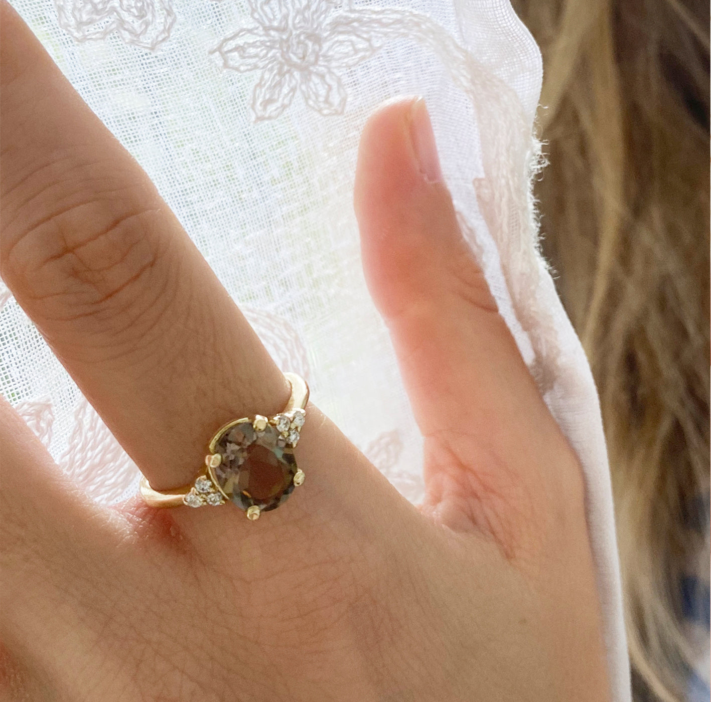 Gold ring set with light smoky quartz in an oval cut and diamonds