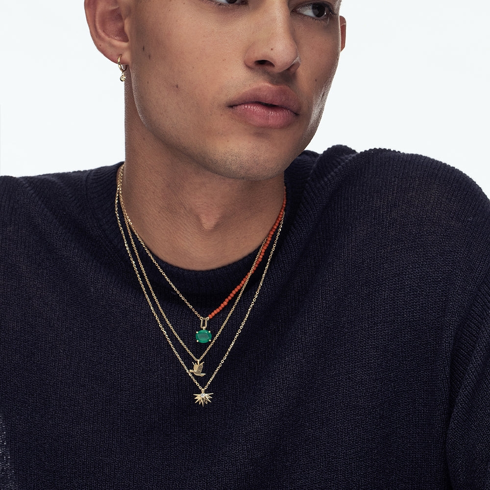 A gold chain combined with natural coral, in the center a green onyx pendant with an oval cut