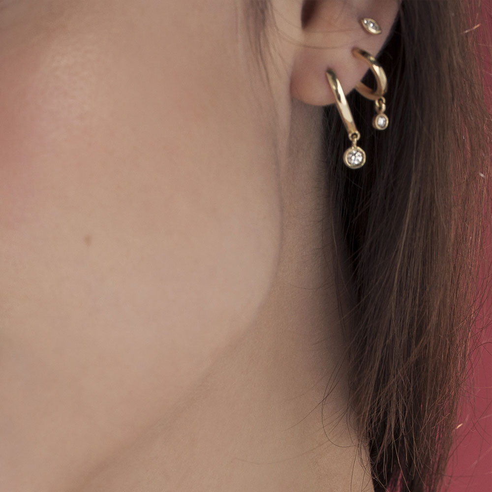 Small gold hoop earrings with a 4-point diamond pendant in a gold frame
