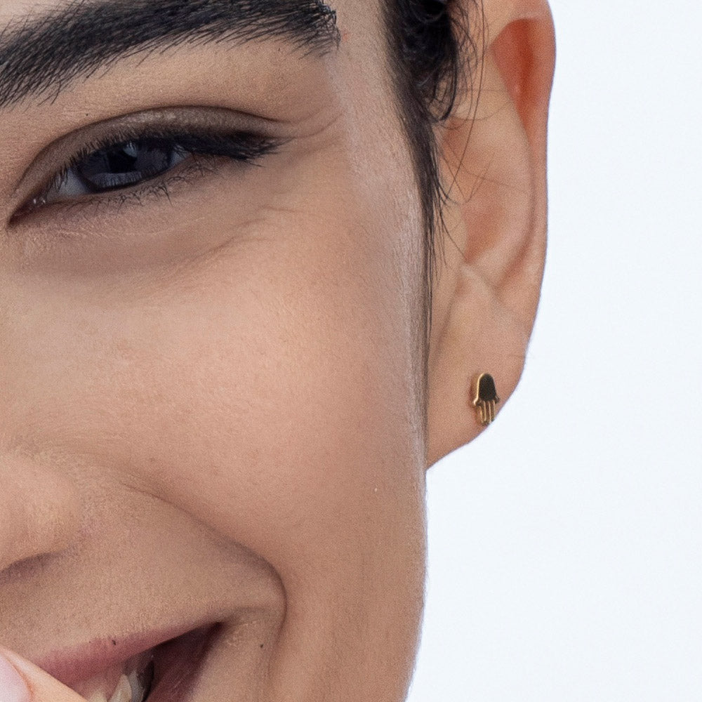 Gold Hamsa earrings close to the ear
