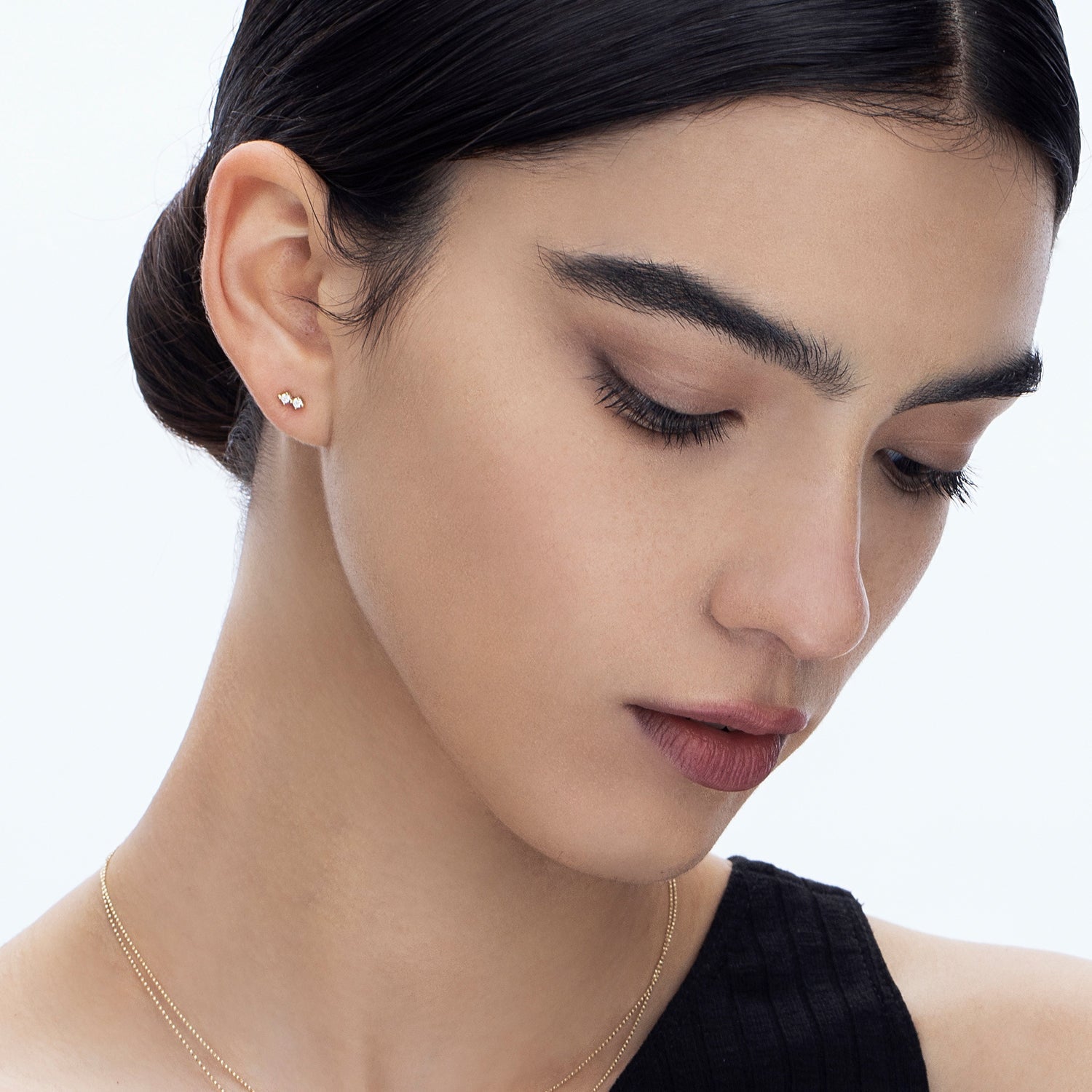Tight gold earrings studded with two diamonds
