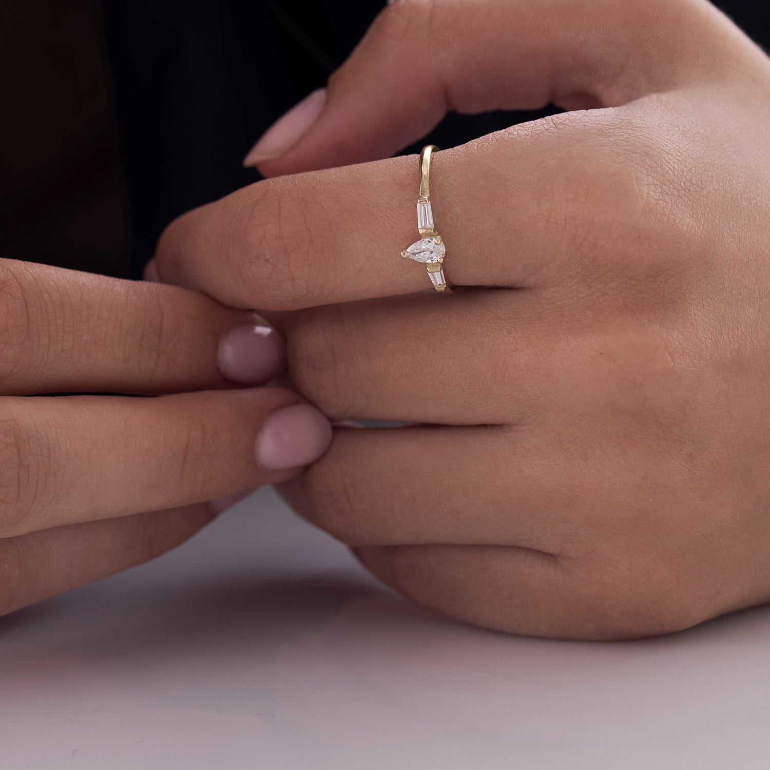 A geometric gold ring set with drop-cut natural diamonds and claws