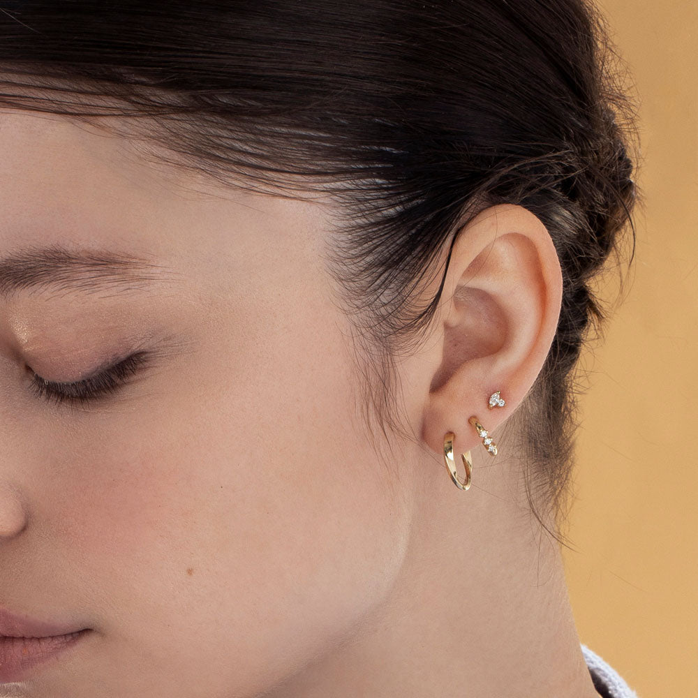 Small gold hoop earrings with a special setting of 3 white diamonds in each earring