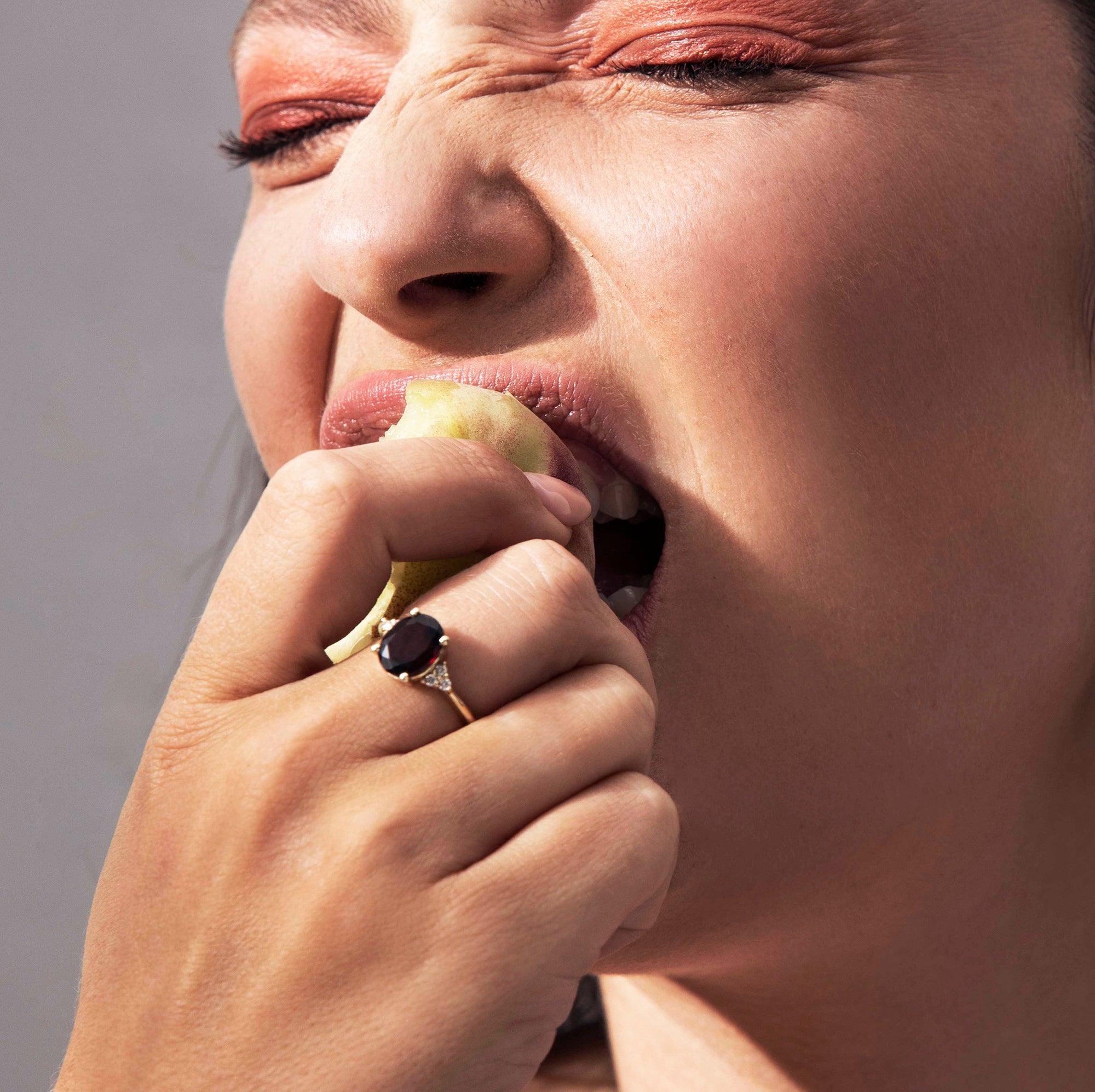 A gold ring set with an oval-cut garnet and diamonds