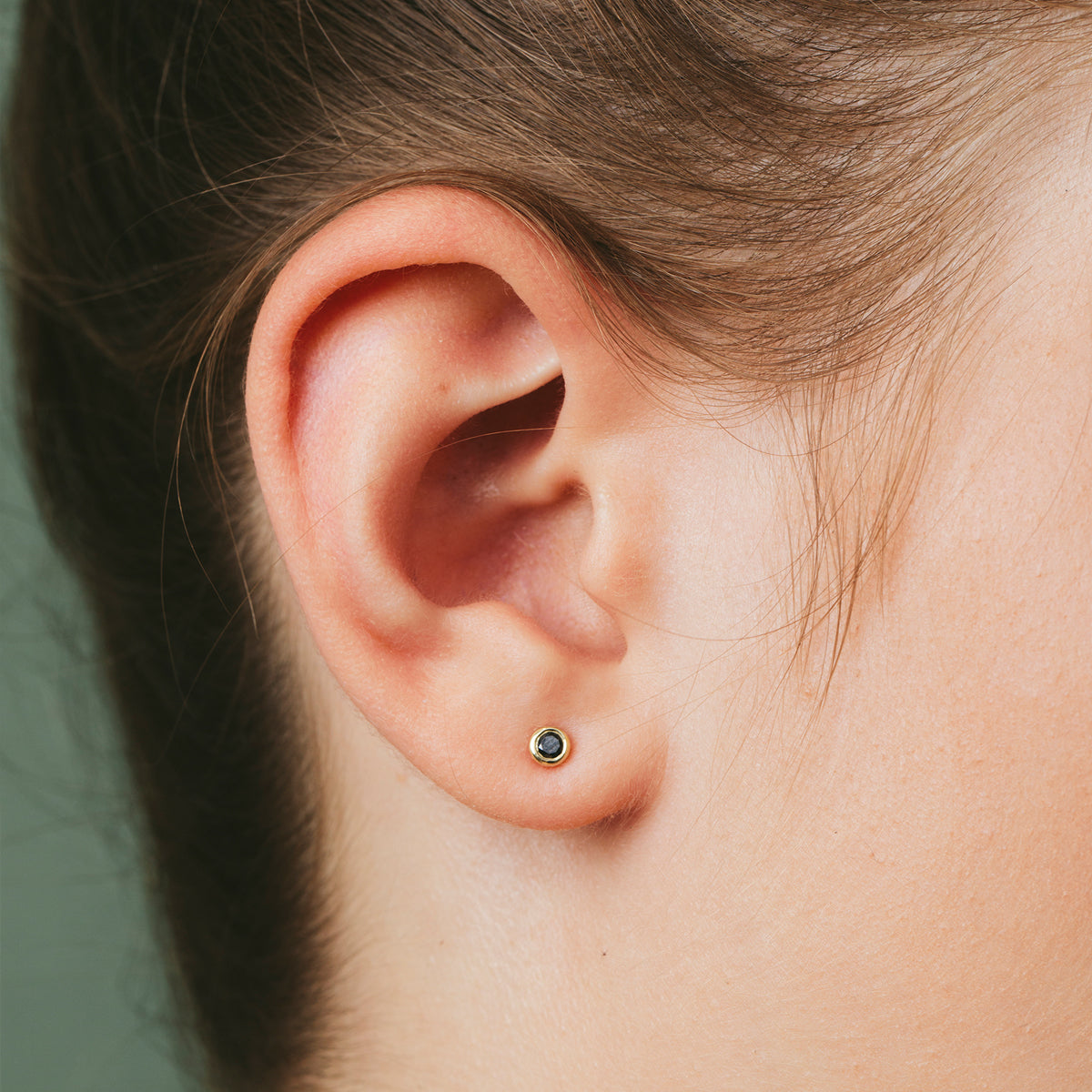 Close-fitting diamond earrings set in a thin gold frame