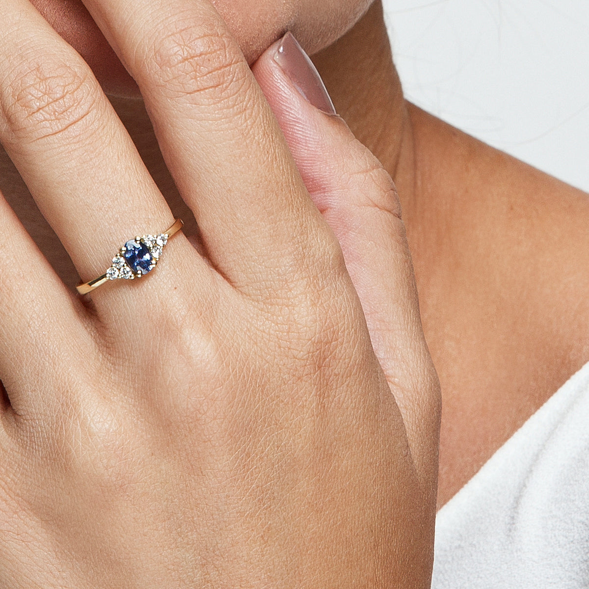 An engagement ring set with an oval-shaped sapphire and 6 sided diamonds