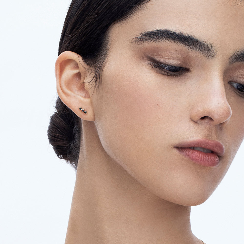 Tight gold earrings set with 3 black diamonds
