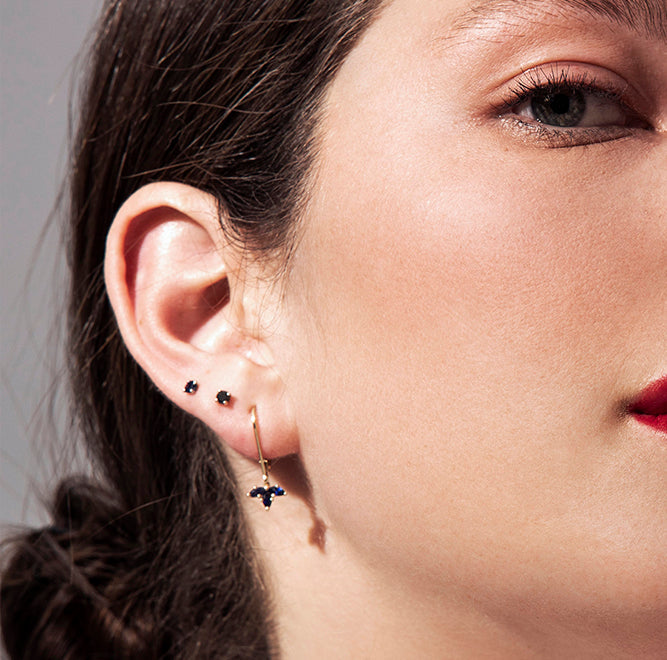 Gold solitaire earrings studded with black diamonds