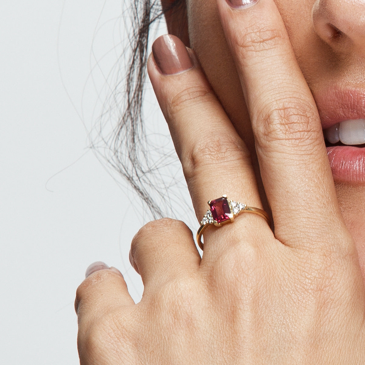 An engagement ring set with a rectangular rhodolite and 6 sided diamonds