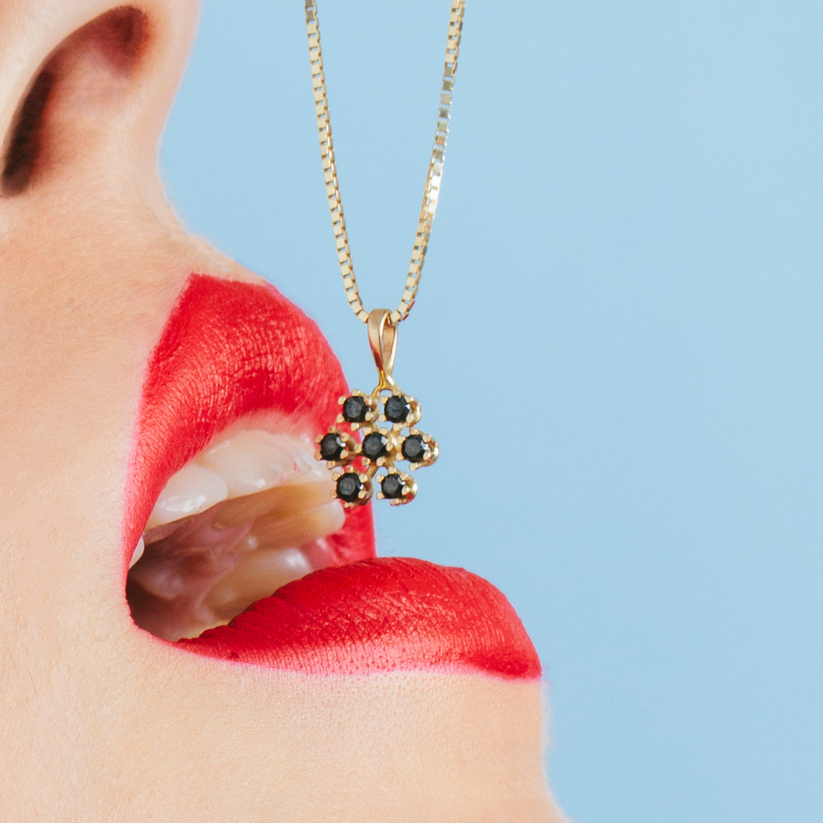 Gold chain and snowflake pendant studded with black diamonds