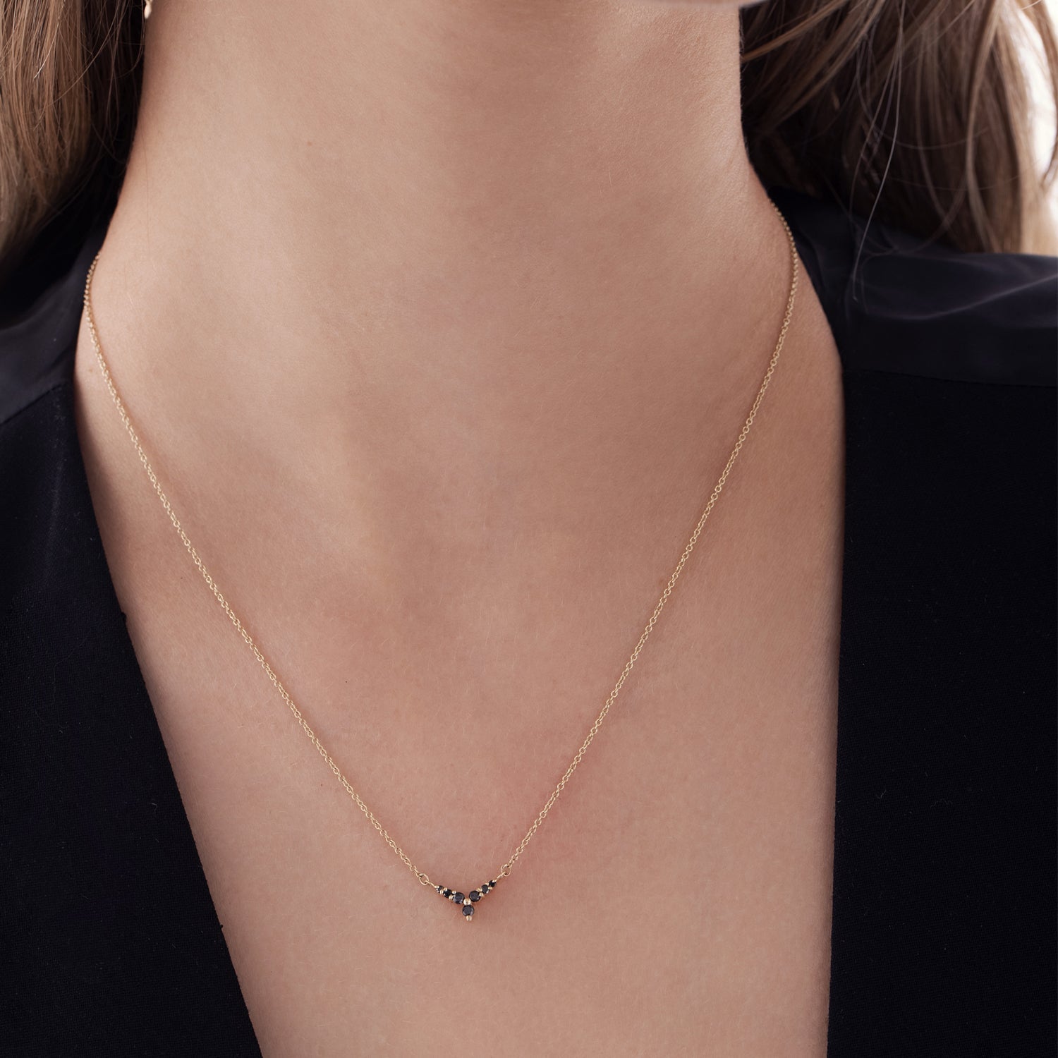 Gold and black diamond necklace with V pendant in a flower design