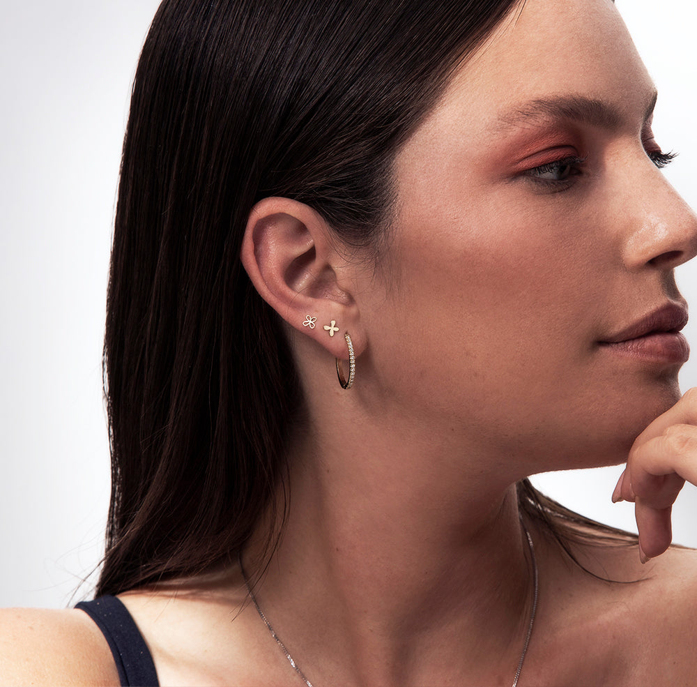 Small tight gold earrings in the shape of a flower