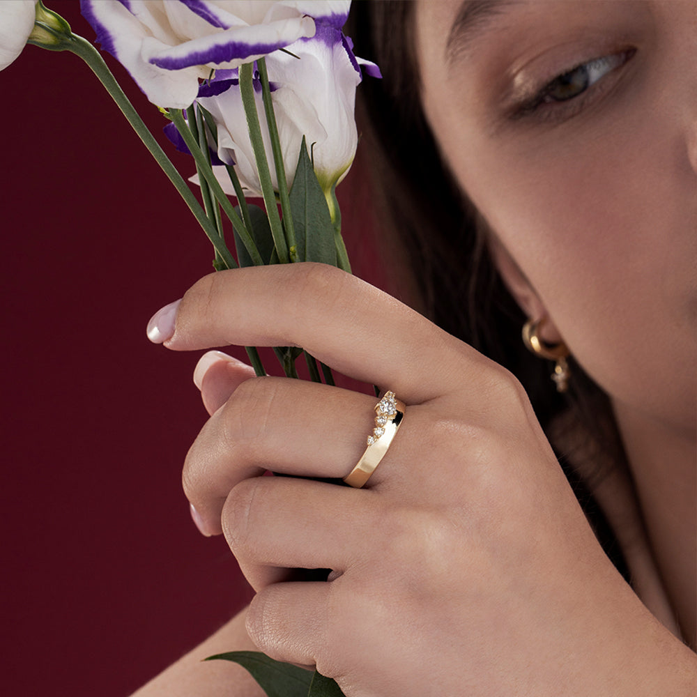 A wide gold ring with a special asymmetric setting of diamonds