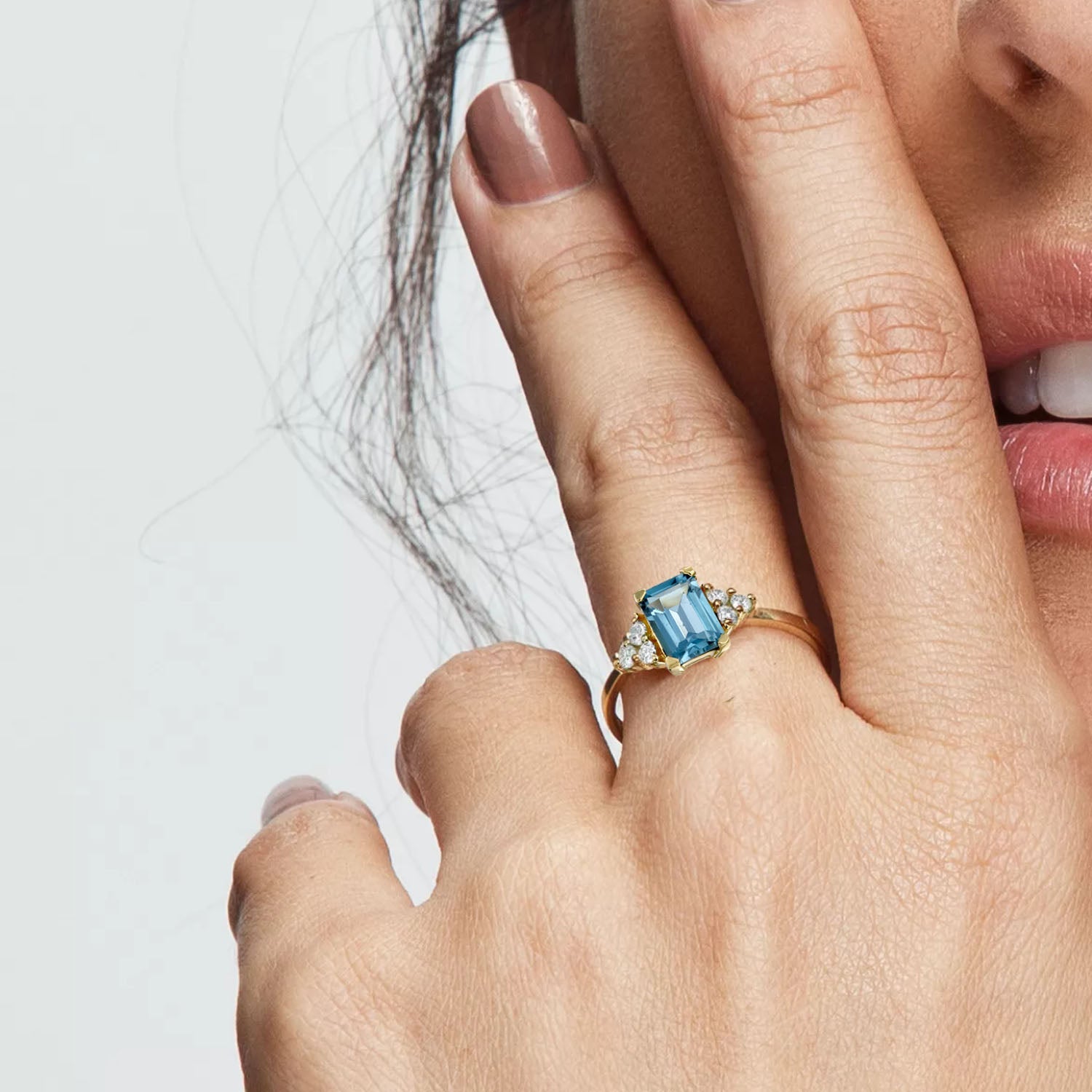 An engagement ring set with rectangular London blue topaz and 6 sided diamonds