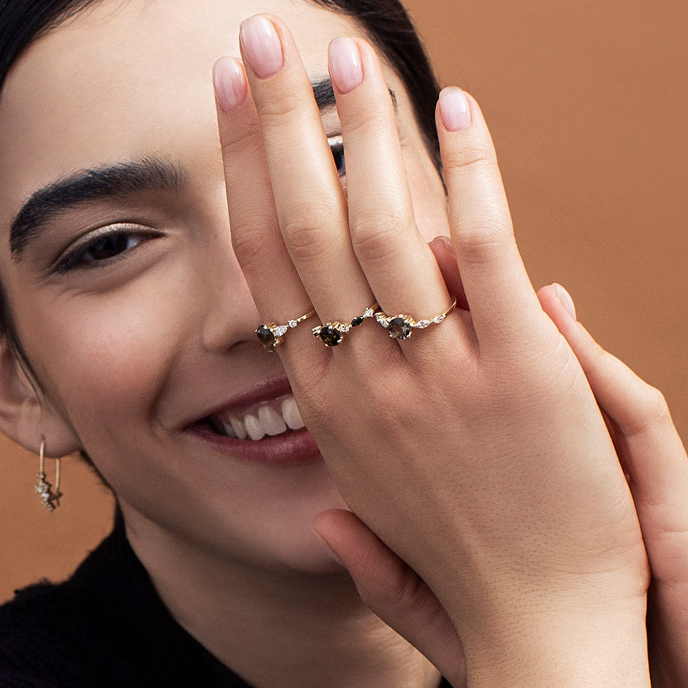 A gold ring set with smoky quartz and drop and round cut diamonds