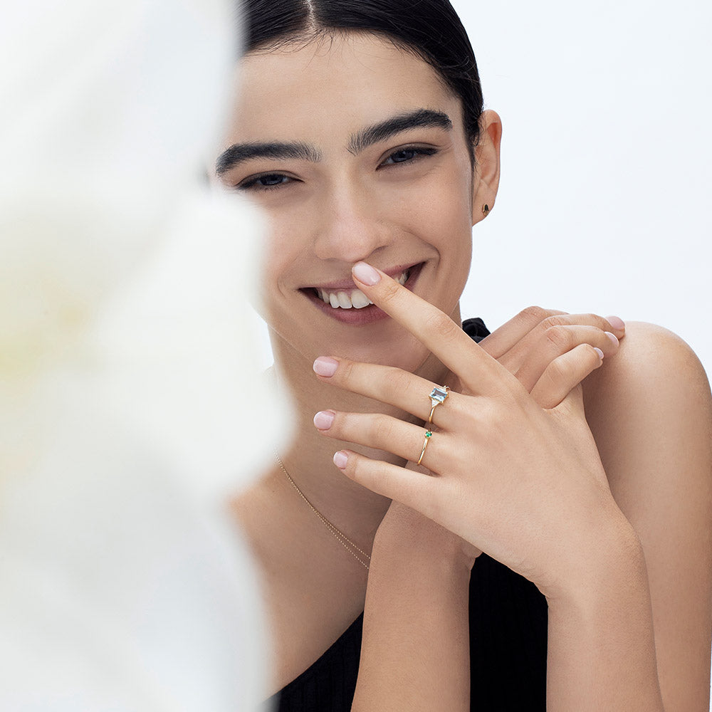 Gold ring set with light London blue topaz and trillion-cut diamonds on the sides