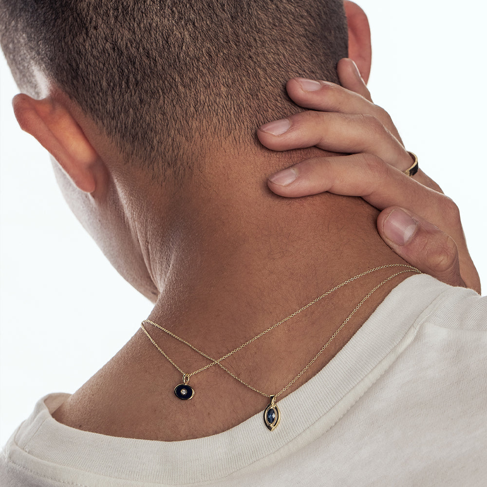 A gold chain with a modern evil eye pendant for men, inlaid with a marquise-cut sapphire