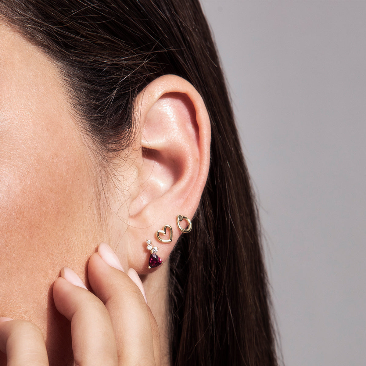 Gold earrings close to the ear in the design of small hearts