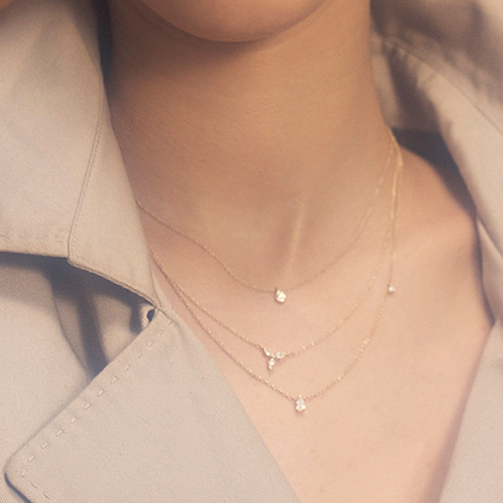 A gold chain set with a drop-cut diamond and a round diamond on the side