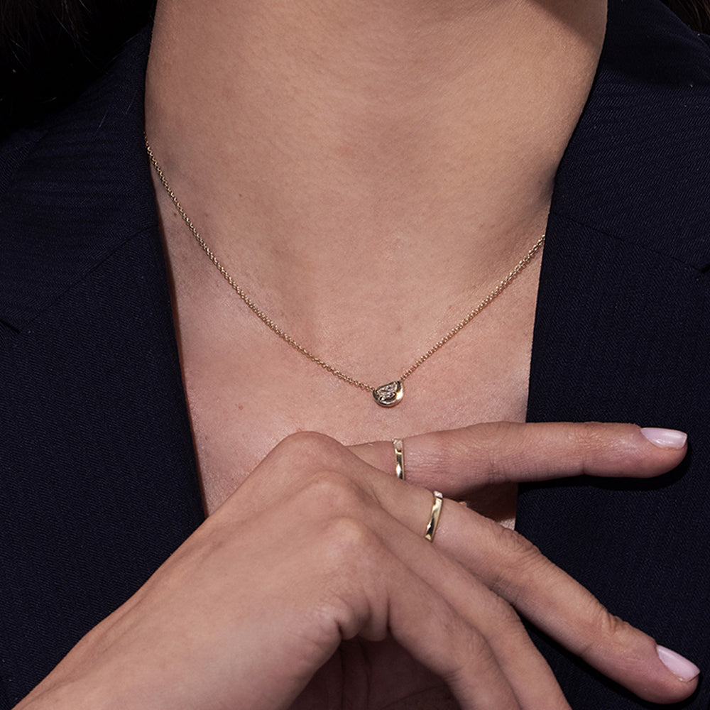 A special gold chain set with a diamond in a semi-circle cut in a modern design
