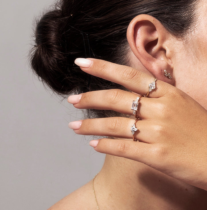 An engagement ring set with a central drop-cut diamond and triangular-cut diamonds on the sides