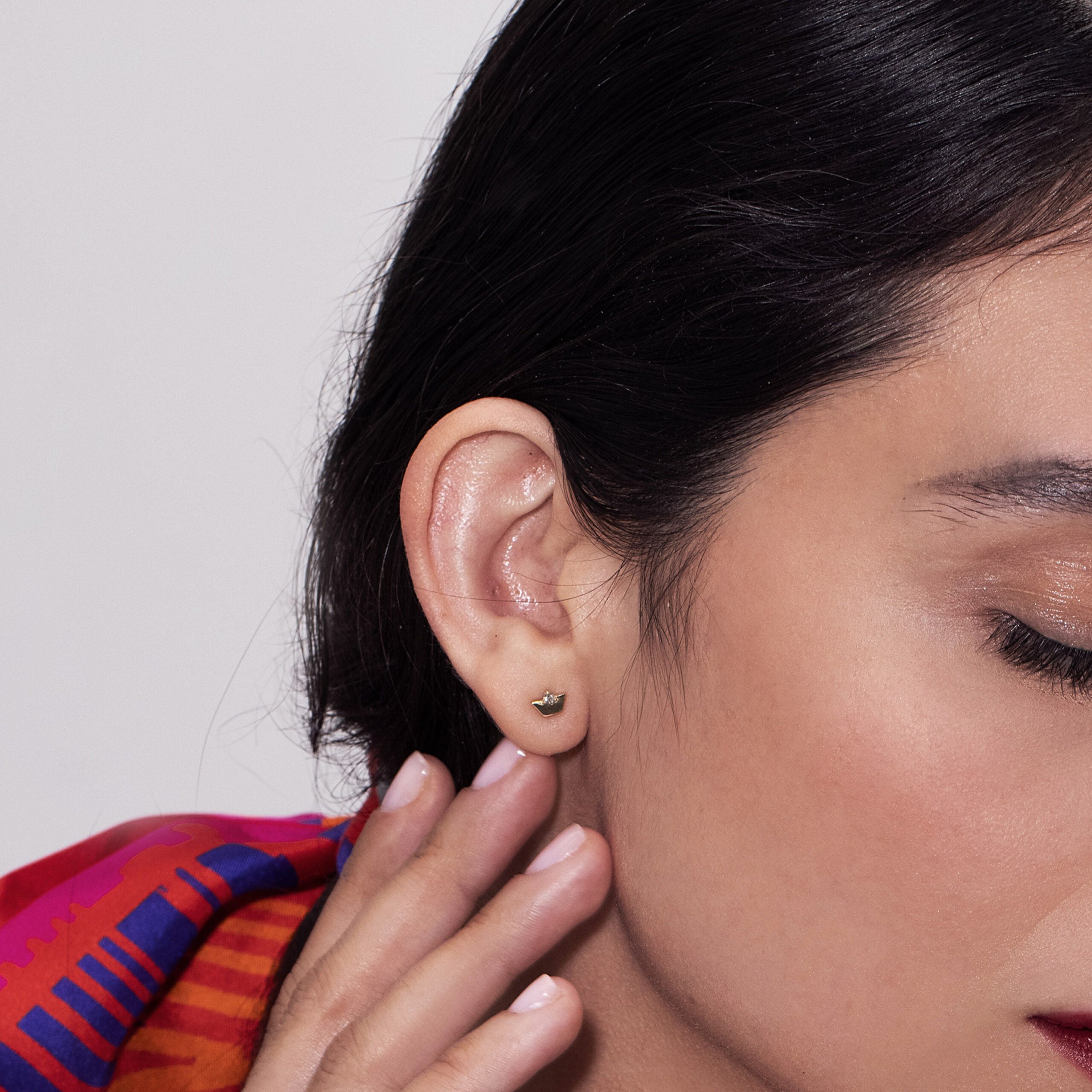 Gold earrings, tight, small, in the form of a dalton, set with a diamond
