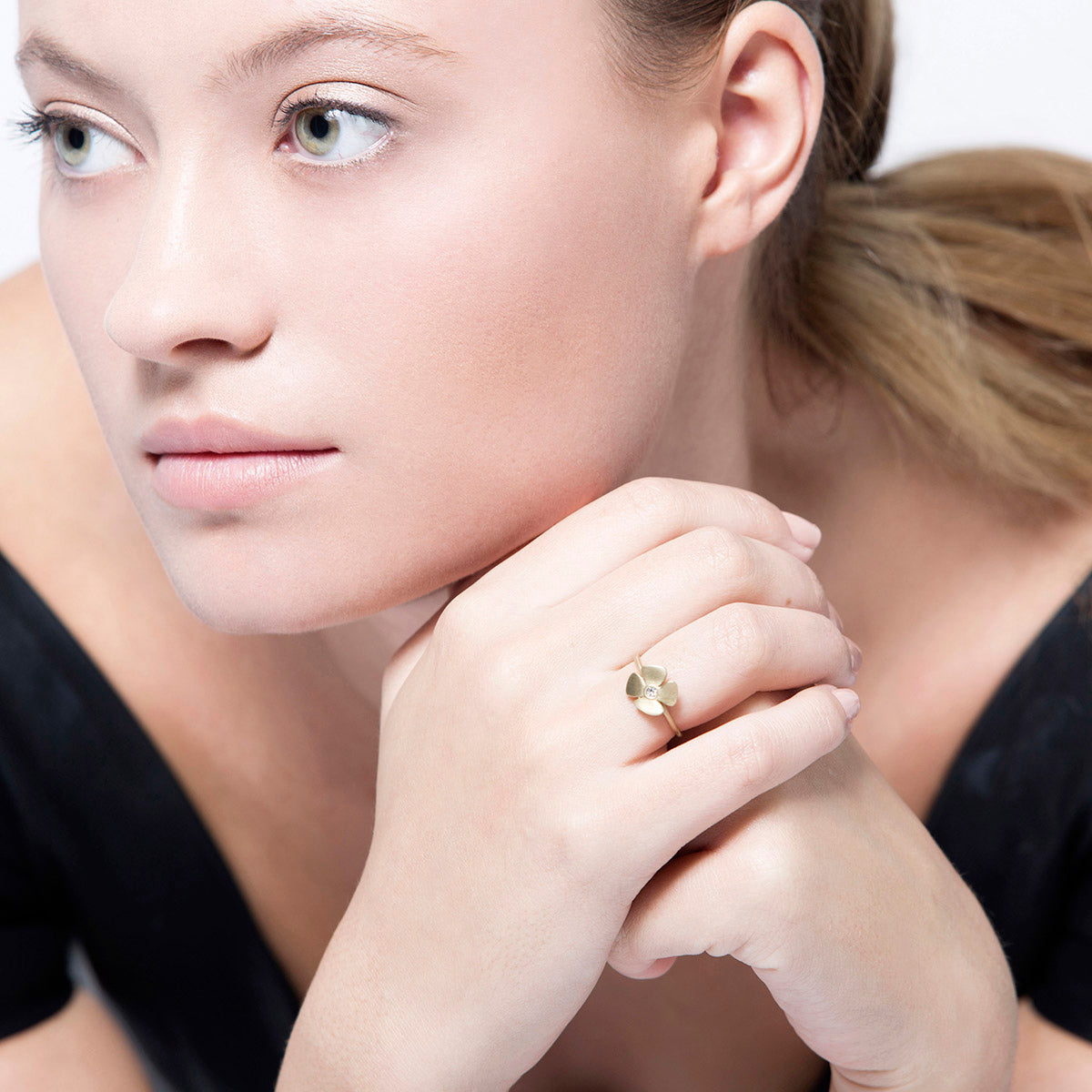 A gold and diamond flower ring with a delicate design
