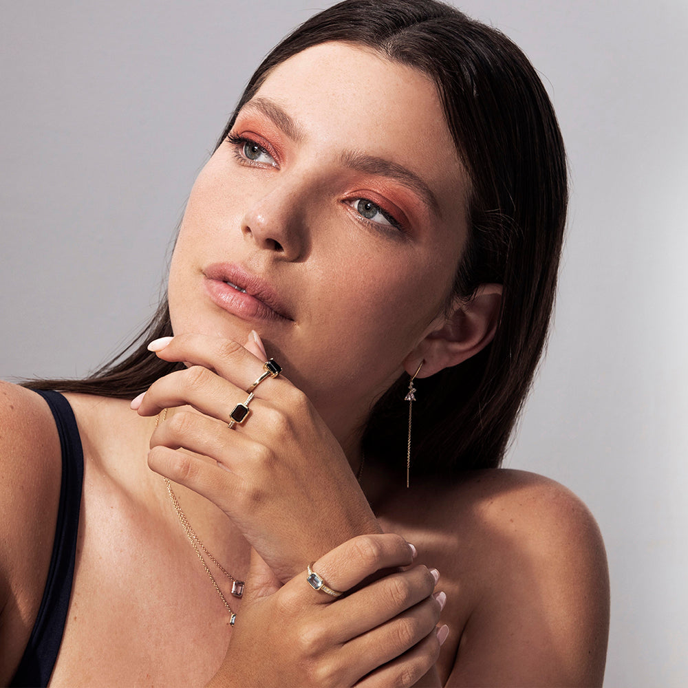 A gold ring set with a smoky quartz stone in a gold frame and white diamonds